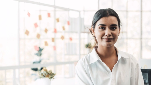 Business person with a whiteboard behind them in a modern office