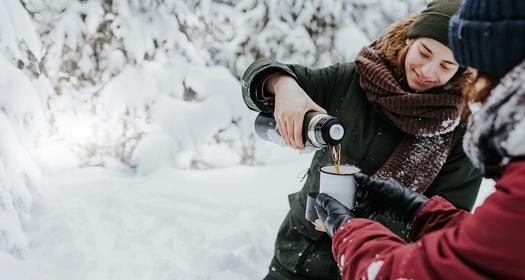 Venner der drikker en kop varm te mens de vandrer