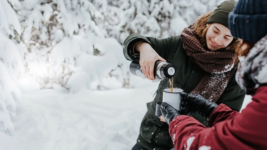 Venner der drikker en kop varm te mens de vandrer