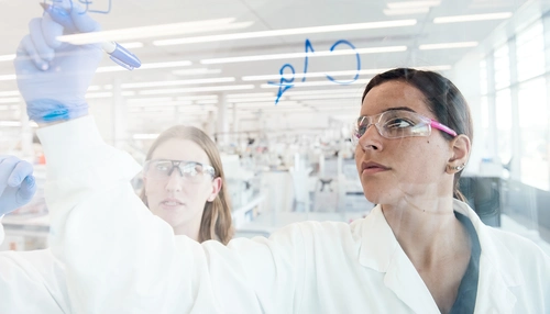 Un scientifique écrit sur un mur de verre