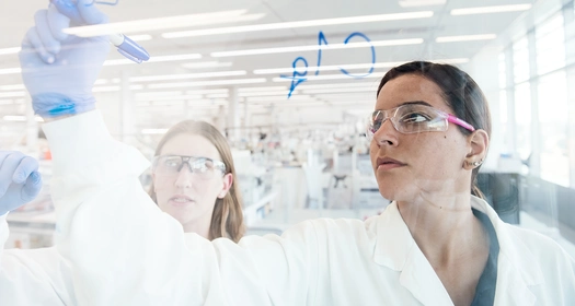 Un scientifique écrit sur un mur de verre