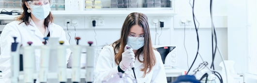 Two scientists in a lab testing samples.